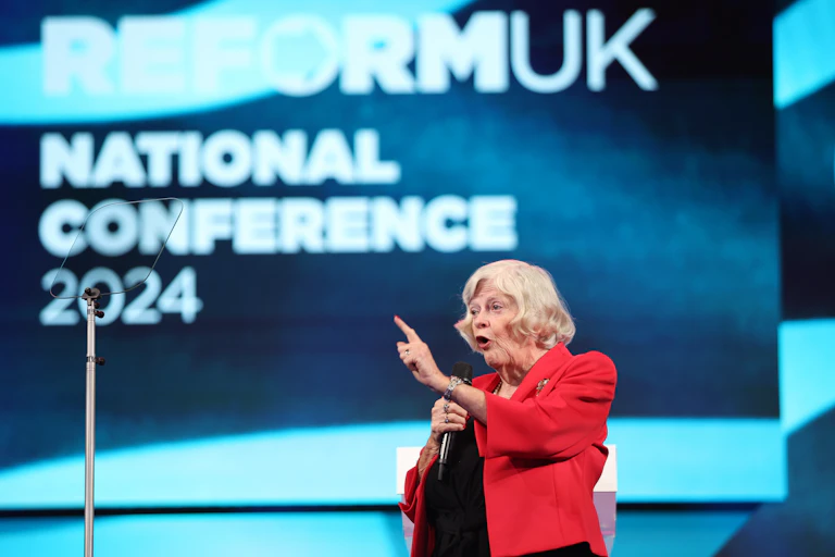 Widdecome onstage in front of a Reform UK conference backdrop