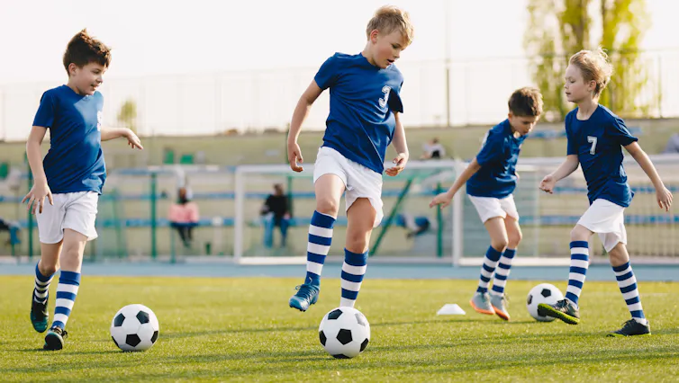Un grupo de niños entrenan con balones de fútbol
