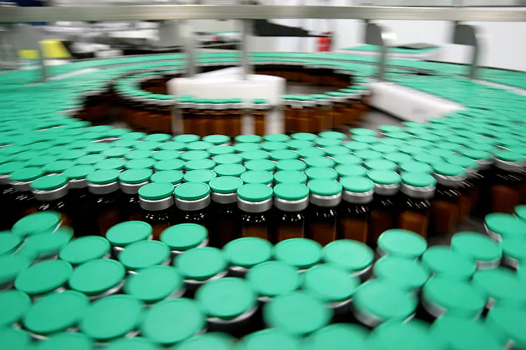 Mantener los medicamentos libres de contaminantes: los fabricantes farmacéuticos filtran los medicamentos a través de poros diminutos para mantenerlos estériles y seguros. 1 Una gran variedad de botellas en tres círculos concéntricos en la línea de producción
