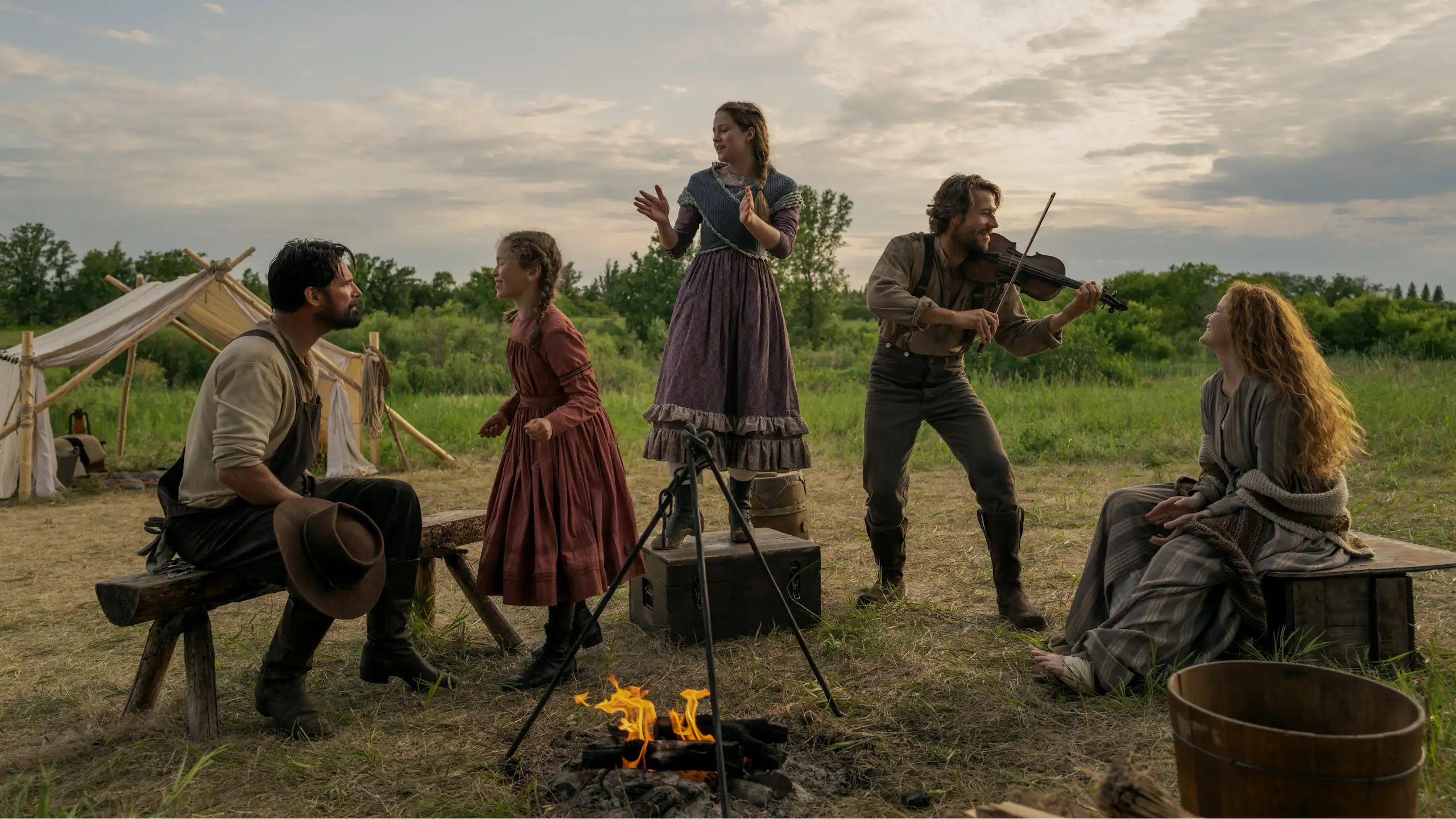 Warren Christie (John Edwards), Alice Halsey (Laura Ingalls), Skywalker Hughes (Mary Ingalls), Luke Bracey (Charles Ingalls) et Crosby Fitzgerald (Caroline Ingalls), autour d'un feu de camp.