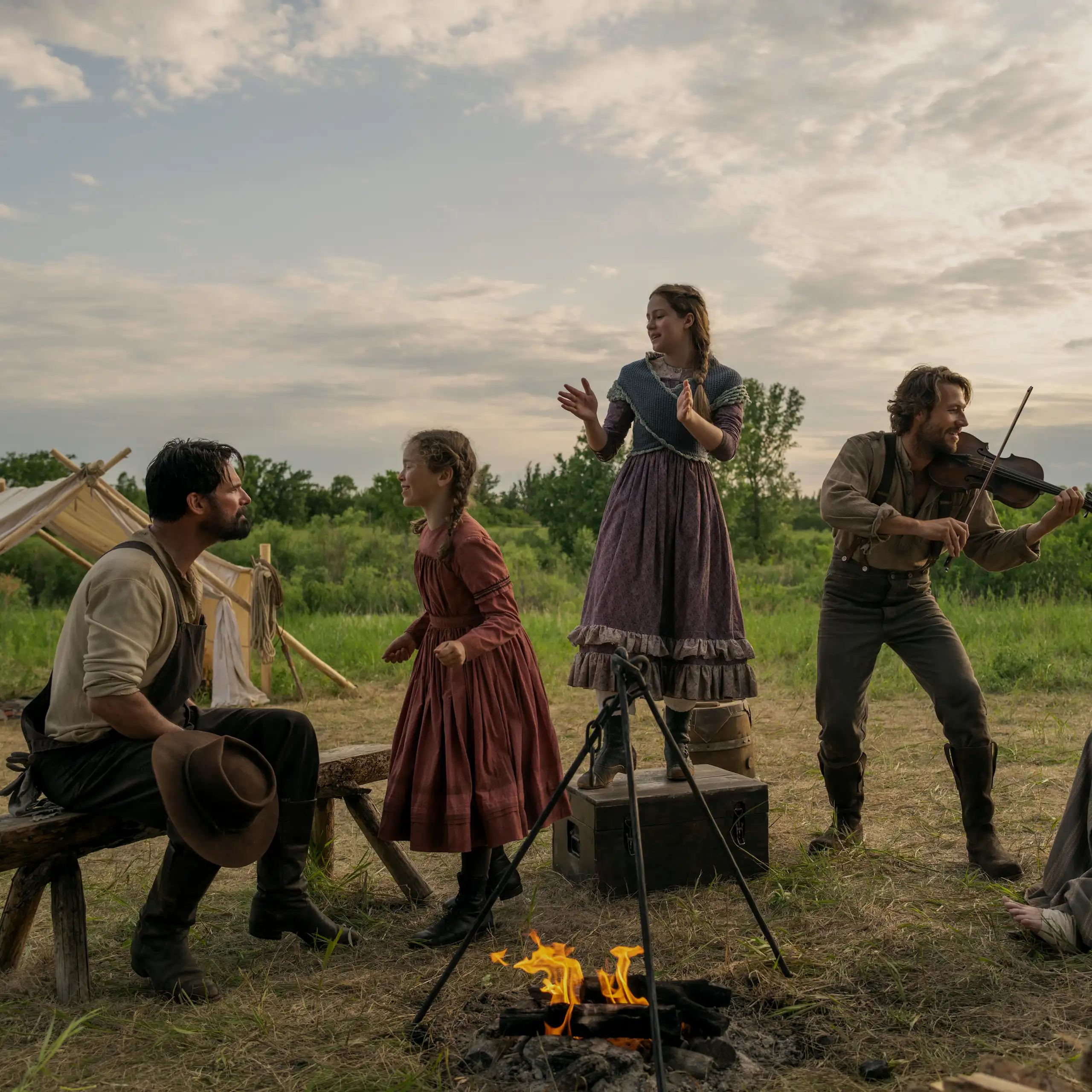 Warren Christie (John Edwards), Alice Halsey (Laura Ingalls), Skywalker Hughes (Mary Ingalls), Luke Bracey (Charles Ingalls) et Crosby Fitzgerald (Caroline Ingalls), autour d'un feu de camp.