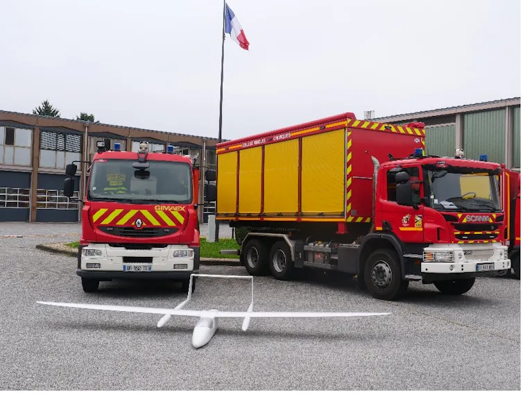 drone à voilure fixe conçu en matériaux composites (fibres de verre et carbone) devant des vehicules de sapeurs pompiers
