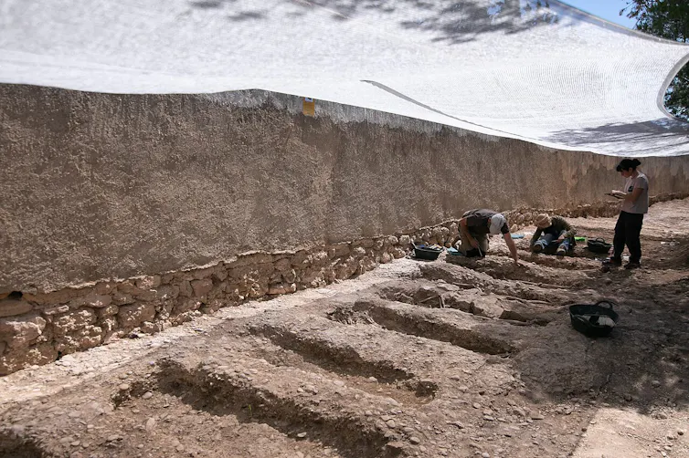 Imagen de tres personas excavando con cuidado unas fosas.