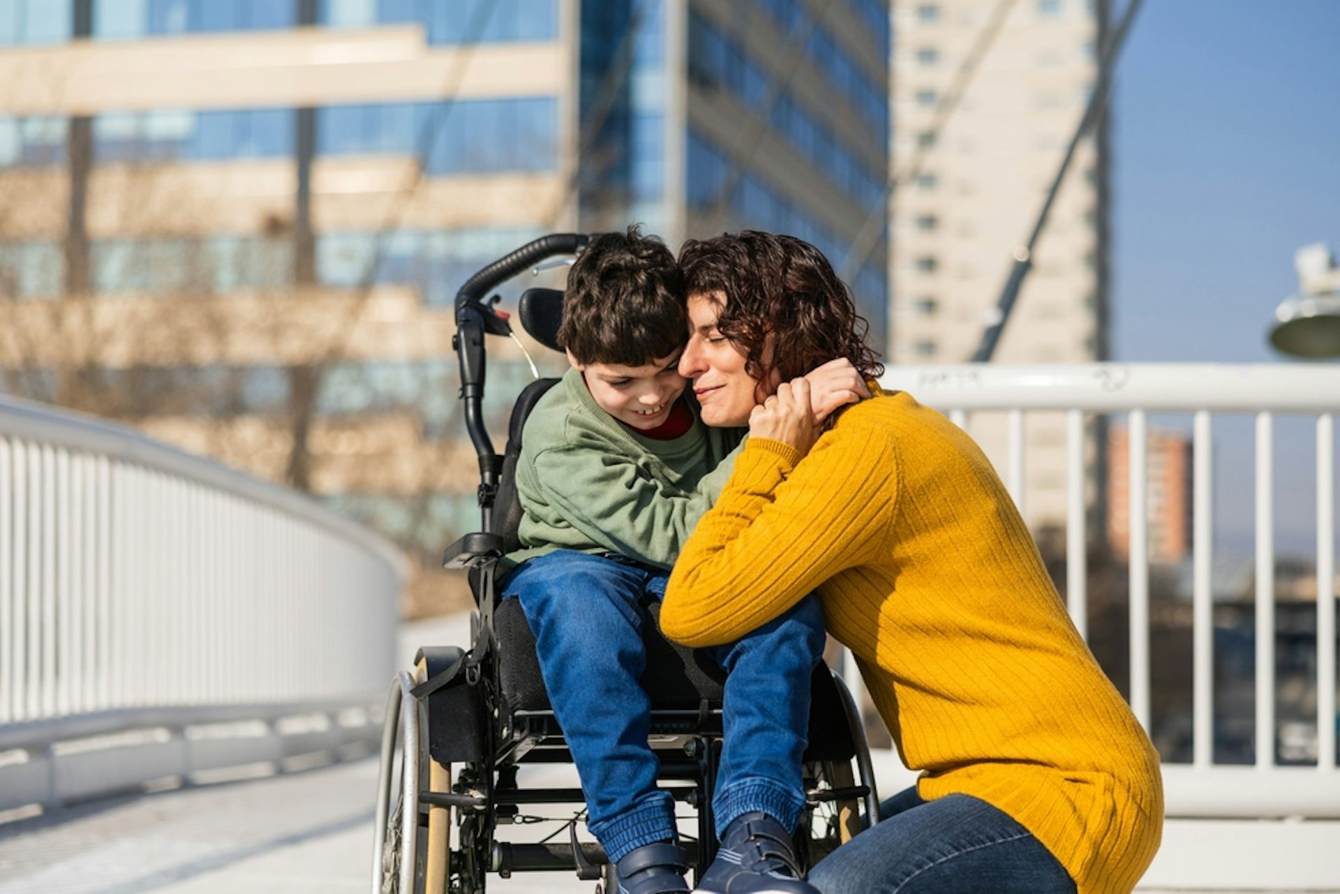 Une mère avec son fils en fauteuil roulant dans une ville.
