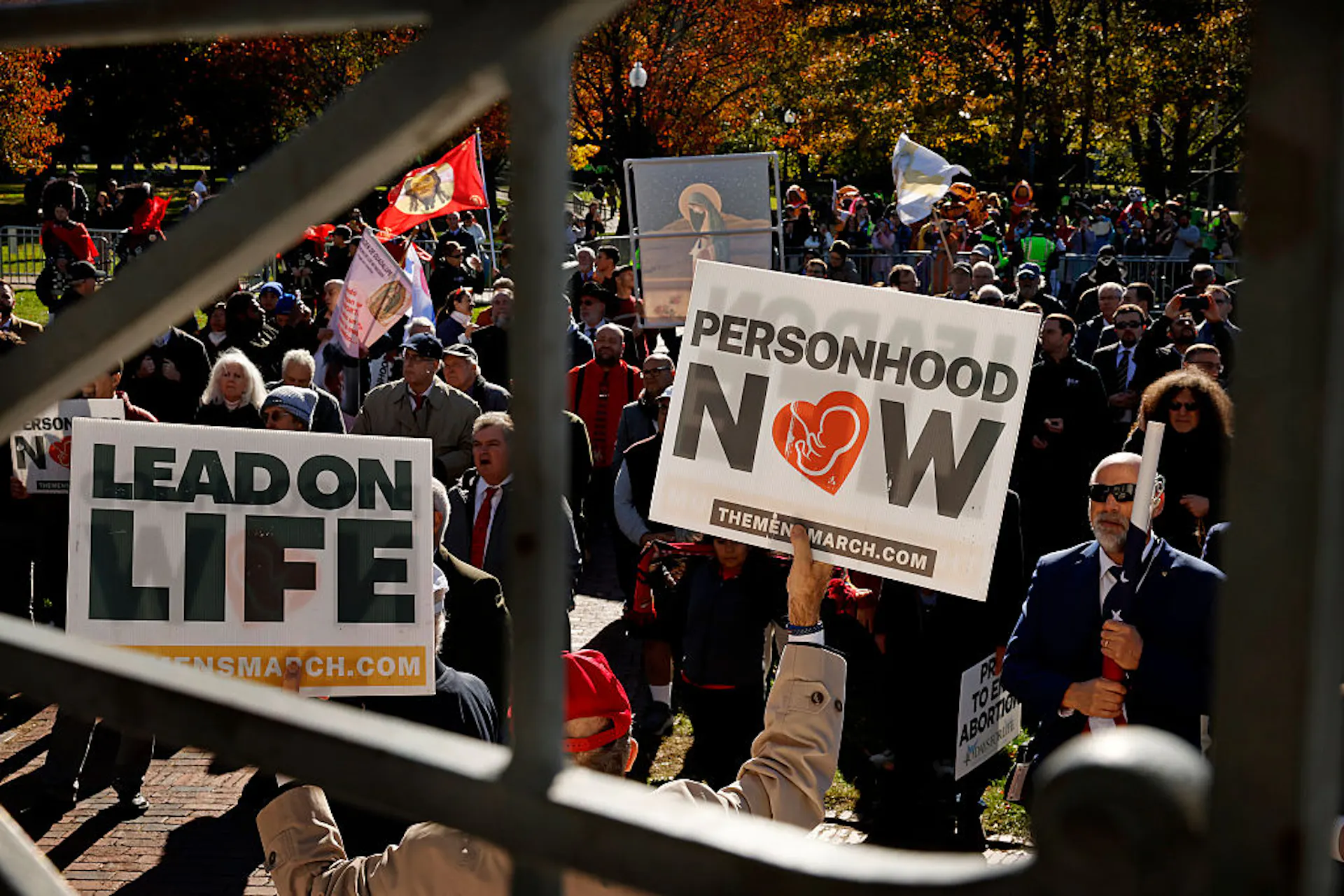 A crowd of people outside holding signs that say 'Personhood now' and 'Lead on life.'
