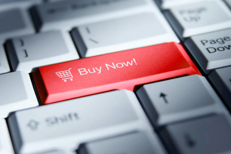 A photo image shows a bright red 'buy now' button on a computer keyboard.