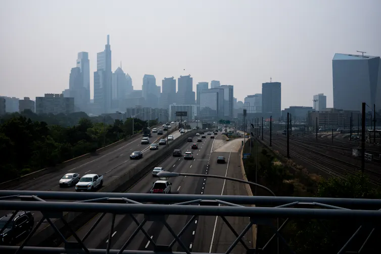 View of smoggy urban skyline in backgorund and highway in foreground