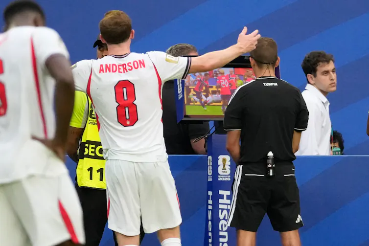 La polémica del VAR en el Mundial muestra por qué los árbitros humanos deberían decidir dónde empiezan las posibles faltas 1 El árbitro revisa imágenes de un partido de fútbol en una pantalla mientras varios jugadores miran