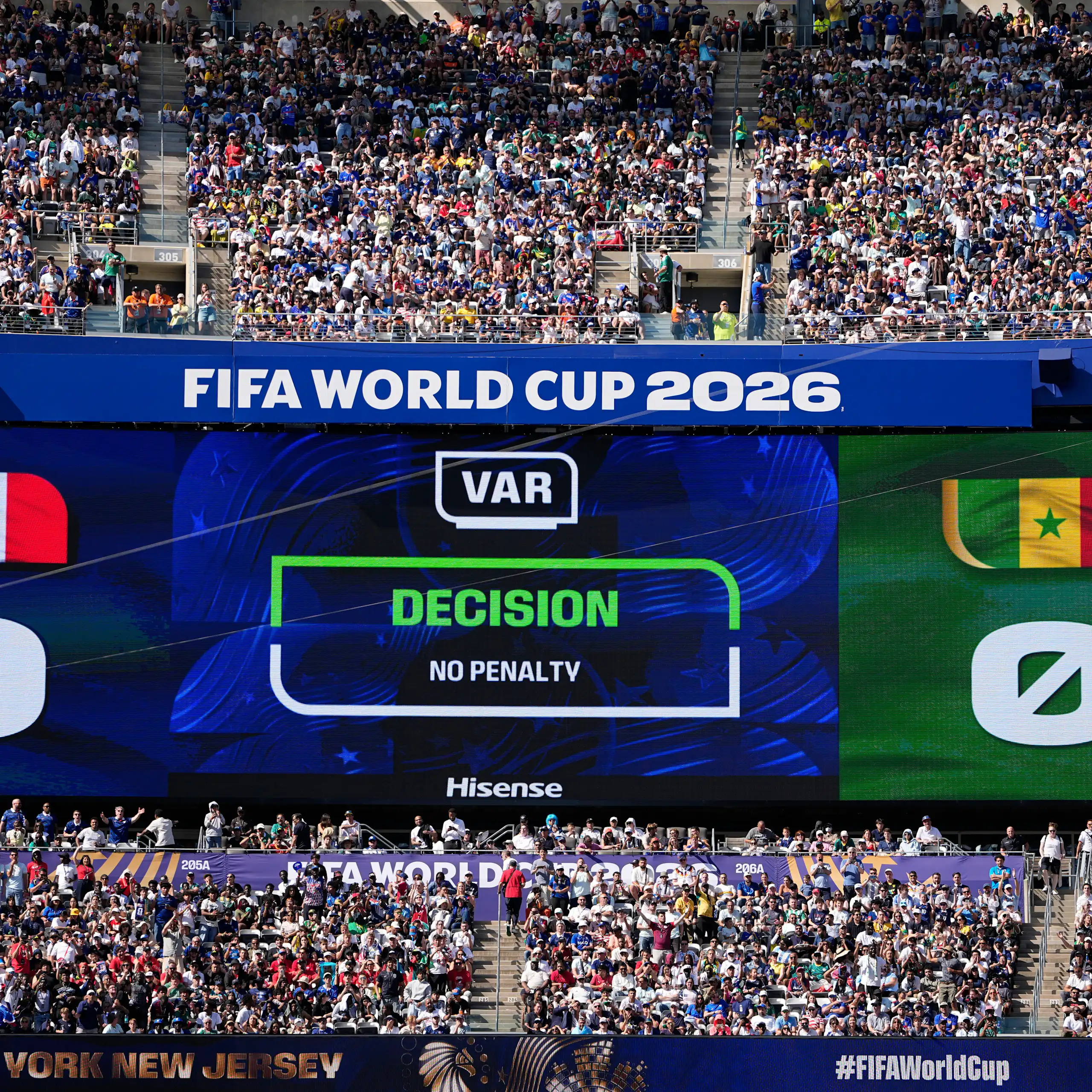 A giant statdium screen screen shows a VAR no-penalty decision during a game between France and Senegal