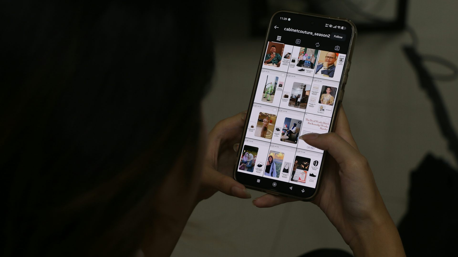 Seseorang memegang ponsel menampilkan akun Instagram berisi foto pejabat dan rincian harga barang yang dikenakan.