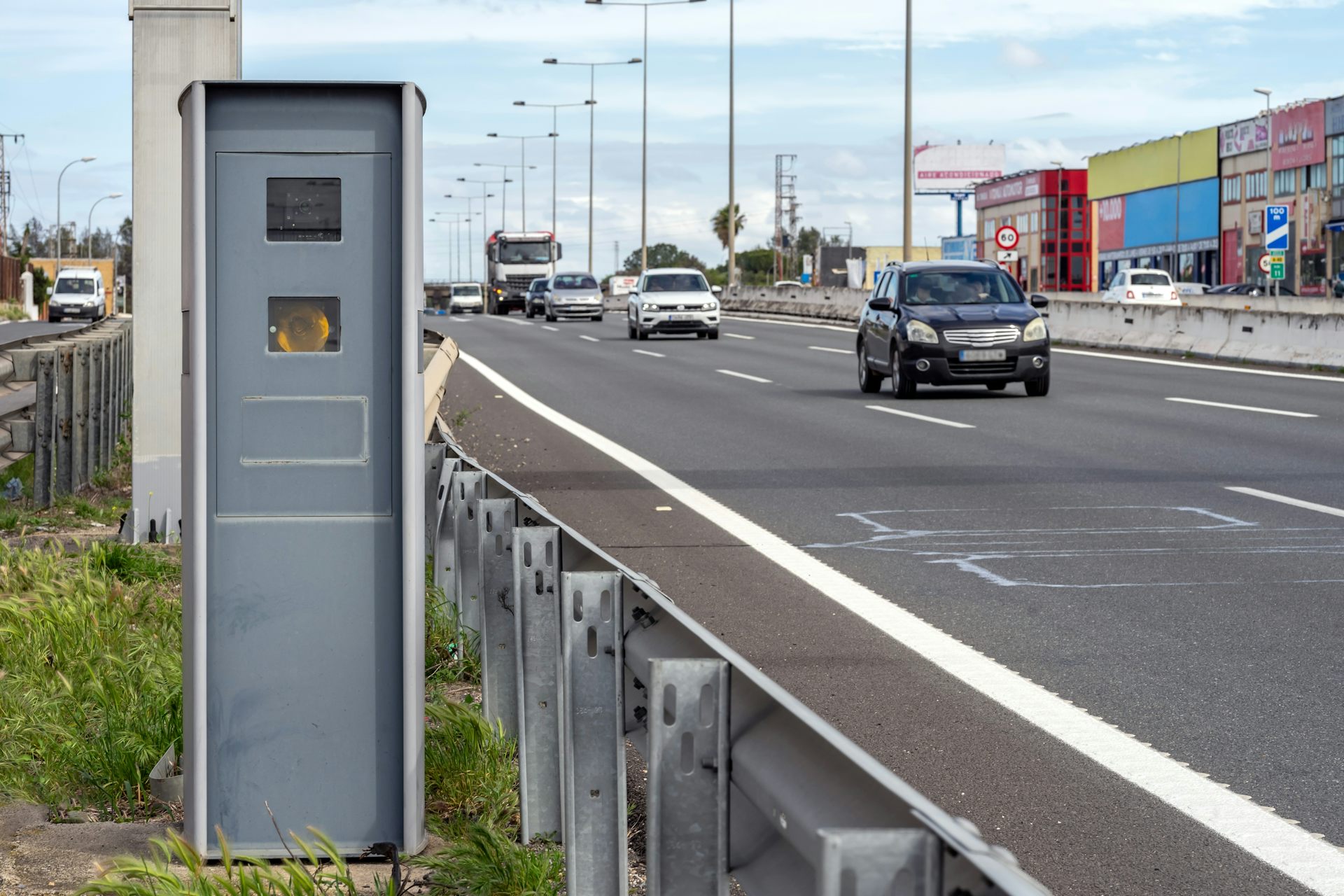 Un radar de velocitat al costat d'una carretera de tres carrils amb trànsit circulant