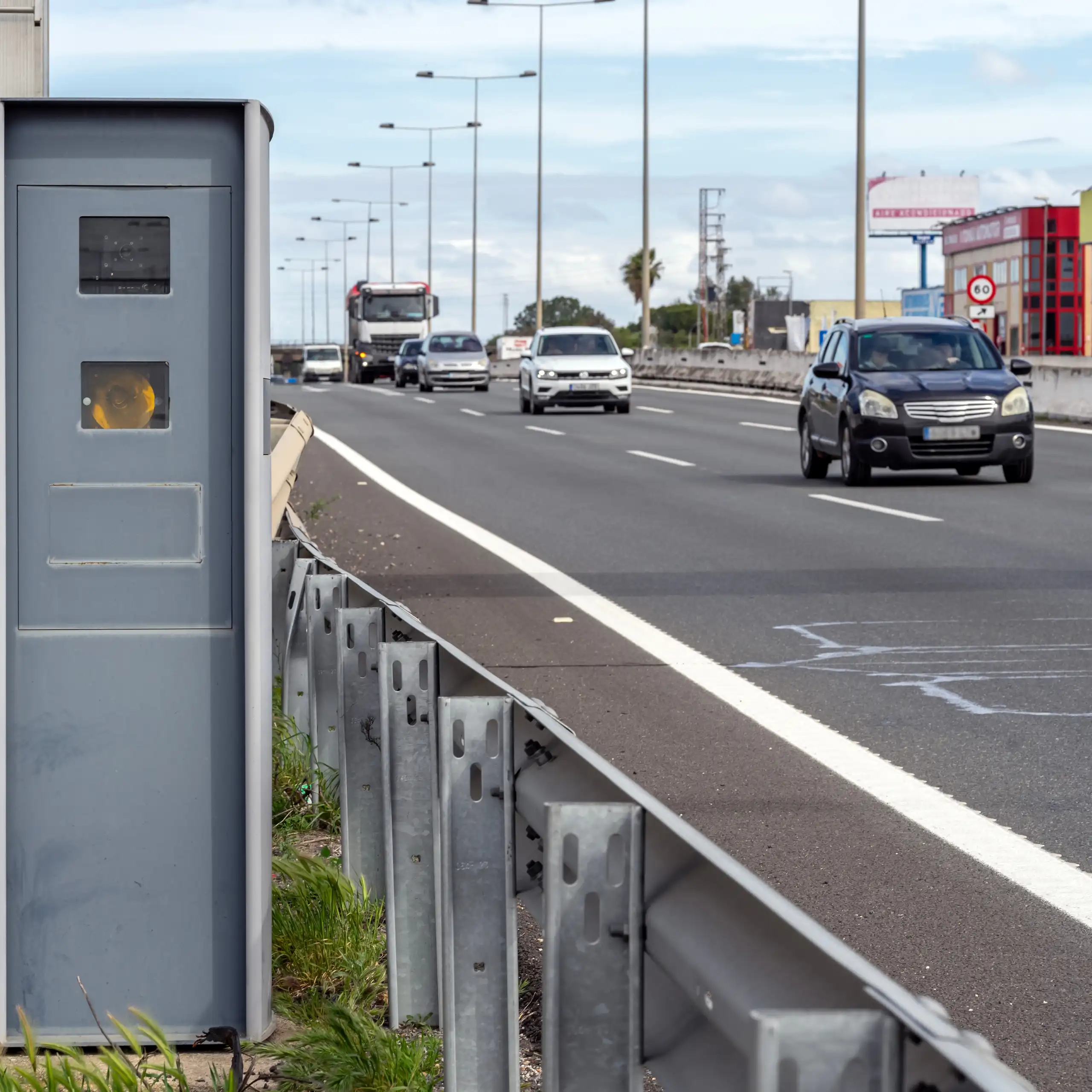 Un radar de velocitat al costat d'una carretera de tres carrils amb trànsit circulant