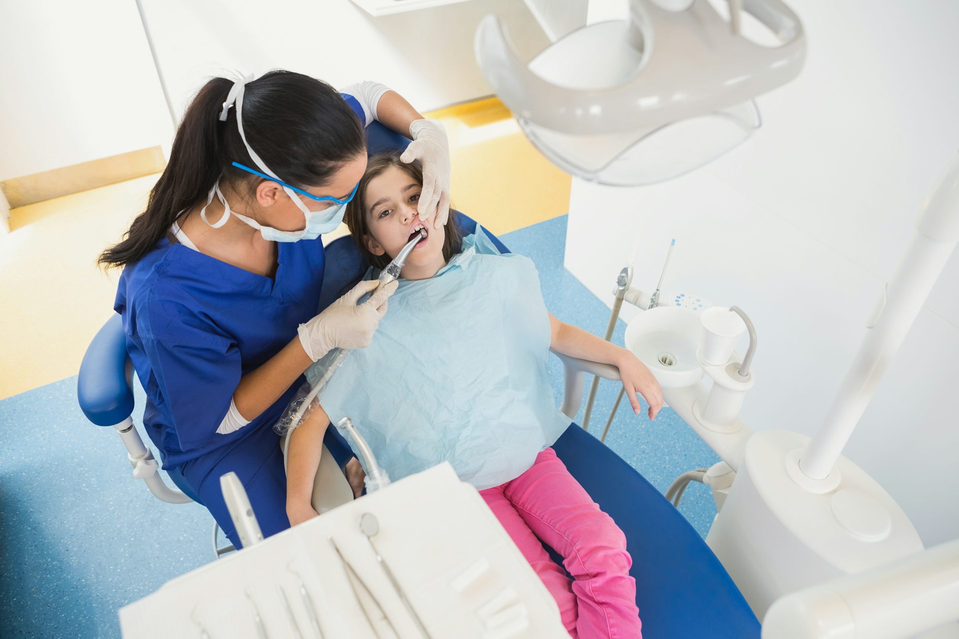 Une petite fille chez le dentiste, pour un examen de sa denture.