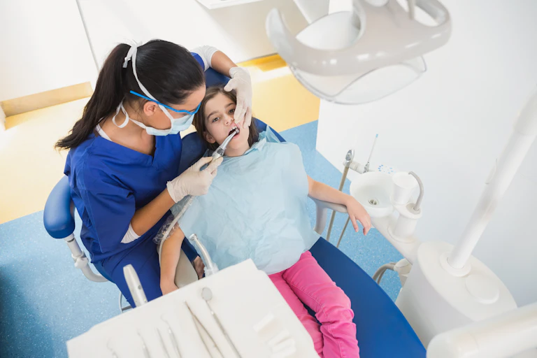 Une petite fille chez le dentiste, pour un examen de sa denture.