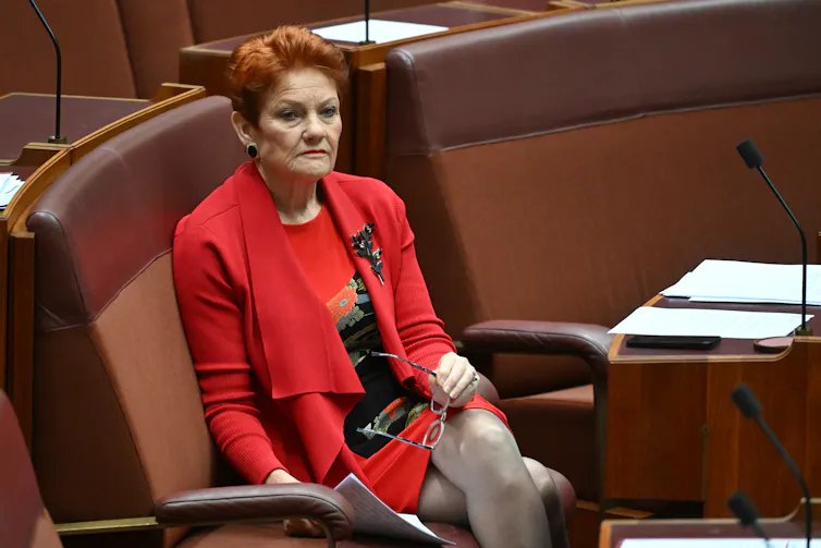 Eine rothaarige Frau im roten Anzug im Senatssaal