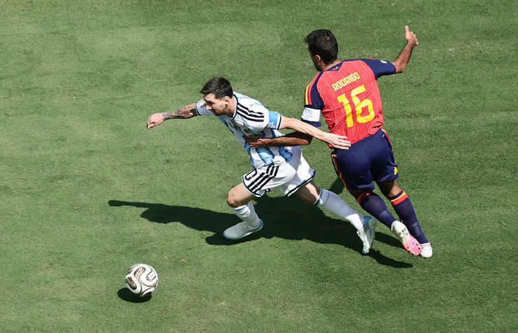 Lionel Messi of Argentina receives close attention from Rodri of Spain.