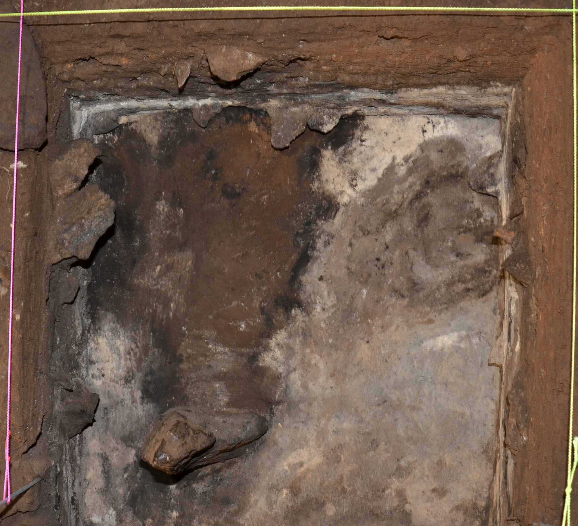Ein auf dem Boden der Cloggs-Höhle markiertes Quadrat mit einem Stein unten links auf dem Foto.