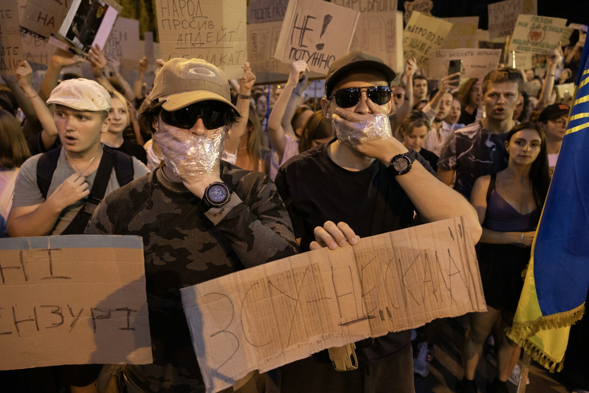 Protestrs cover their mouths with their hands