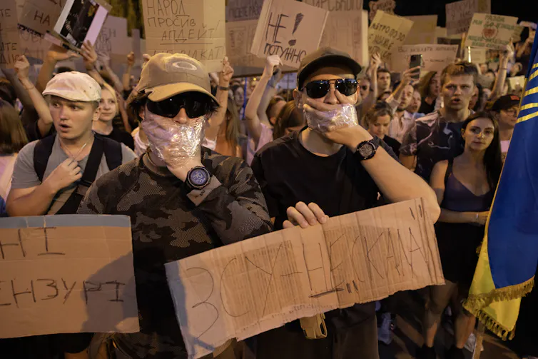 Protestrs cover their mouths with their hands