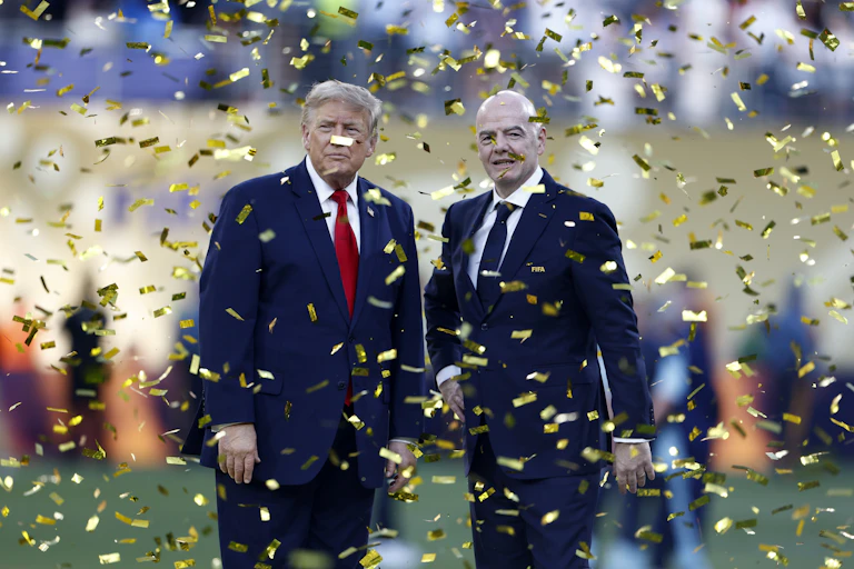 Trump and Infantino standing under gold confetti.