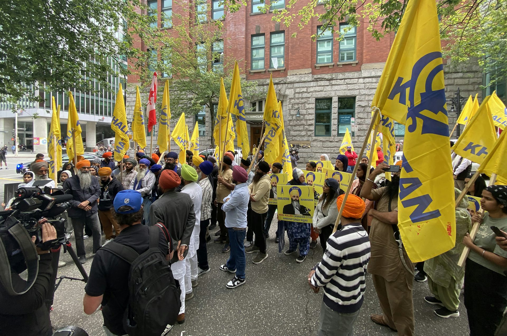 Manifestantes portan banderas amarillas frente al consulado indio