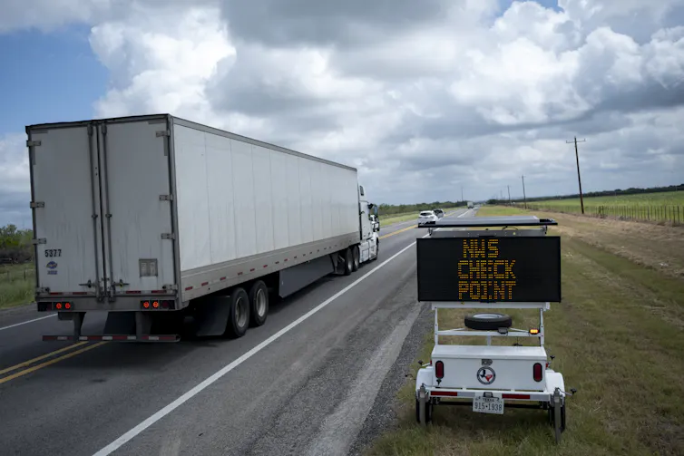 A digital sign placed next to a road alerts drivers of an upcoming checkpoint for screwworms.