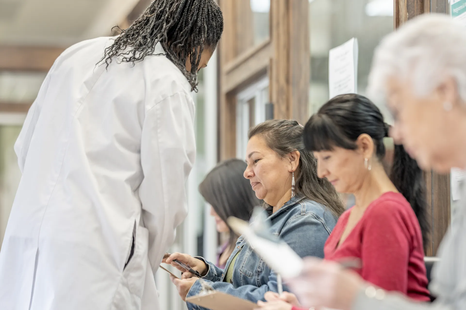 A healthcare worker speaks to a patient in a clinic waiting room