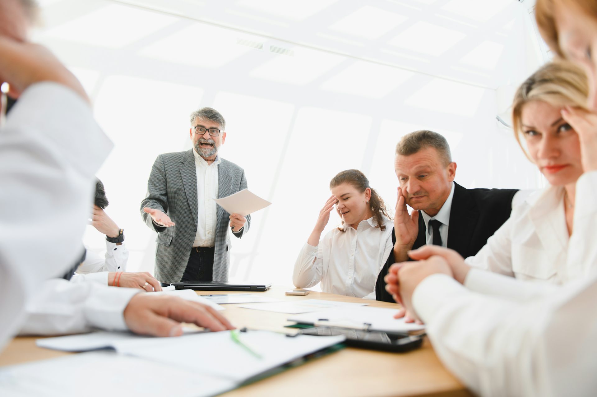 People looking uncomfortable around an office table.