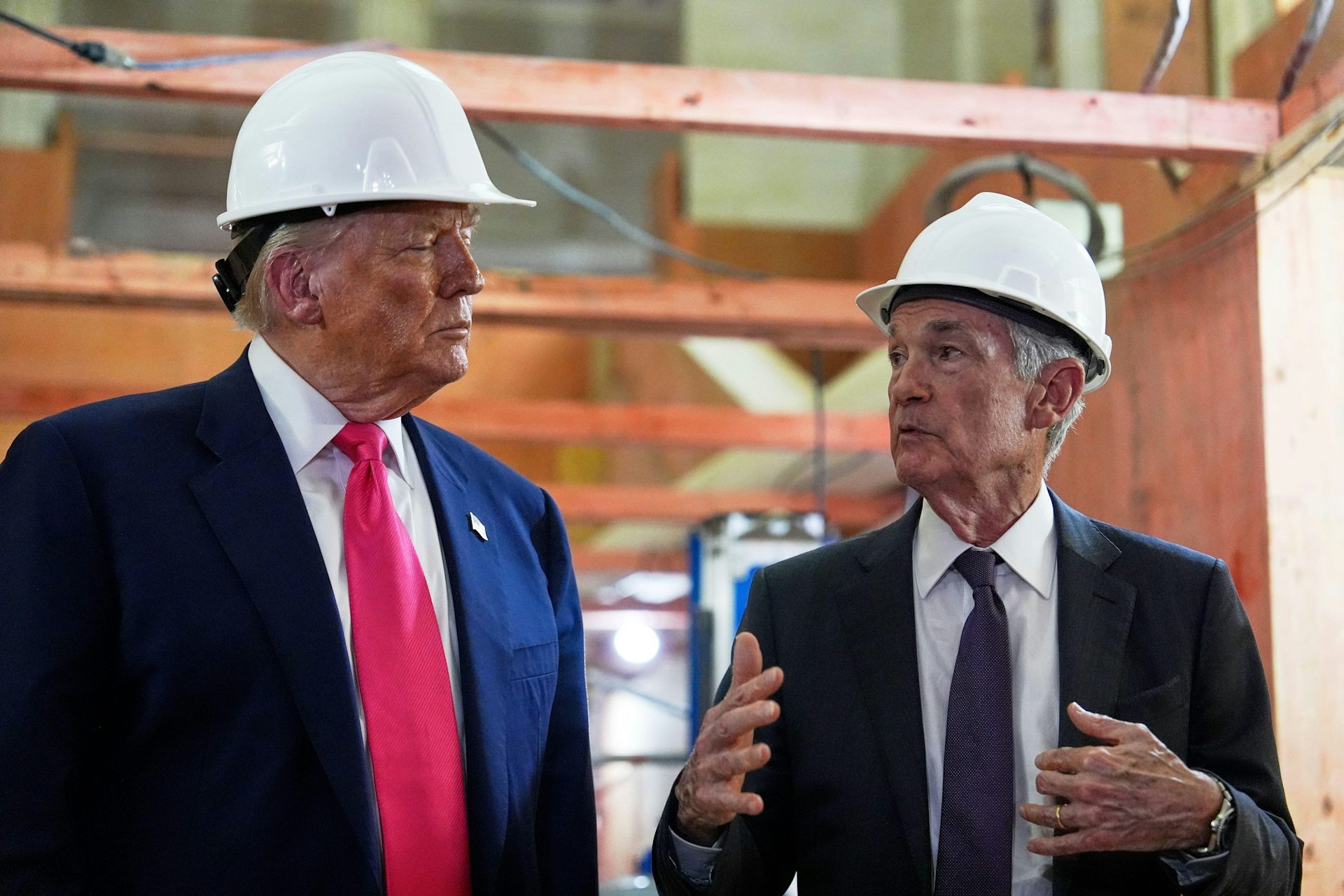 Donald Trump with the Federal Reserve chairman, Jerome Powell, both wearing hard hats.