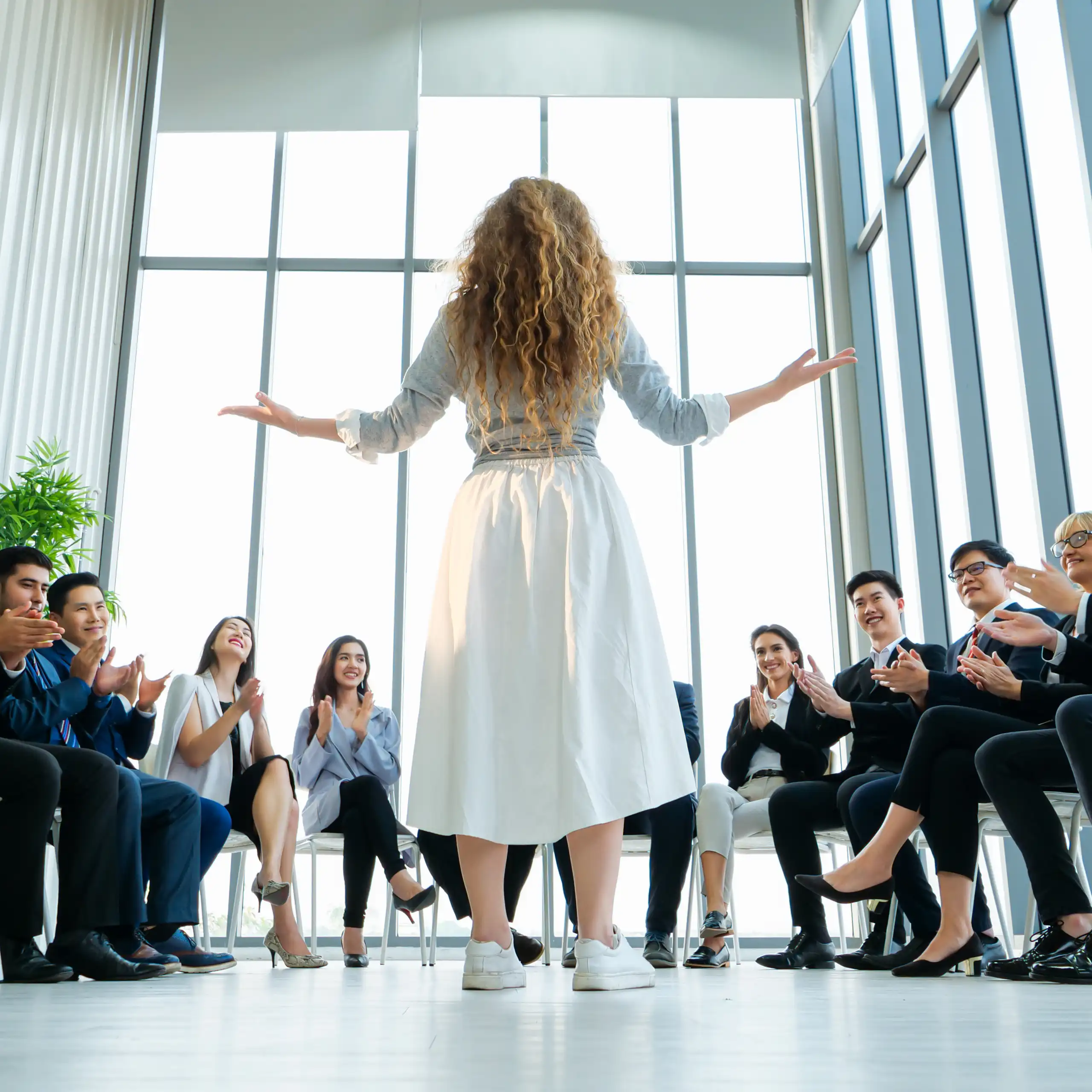 Manageuse devant des collaborateurs assis.