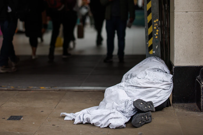 A person sleeping rough outside of a train station