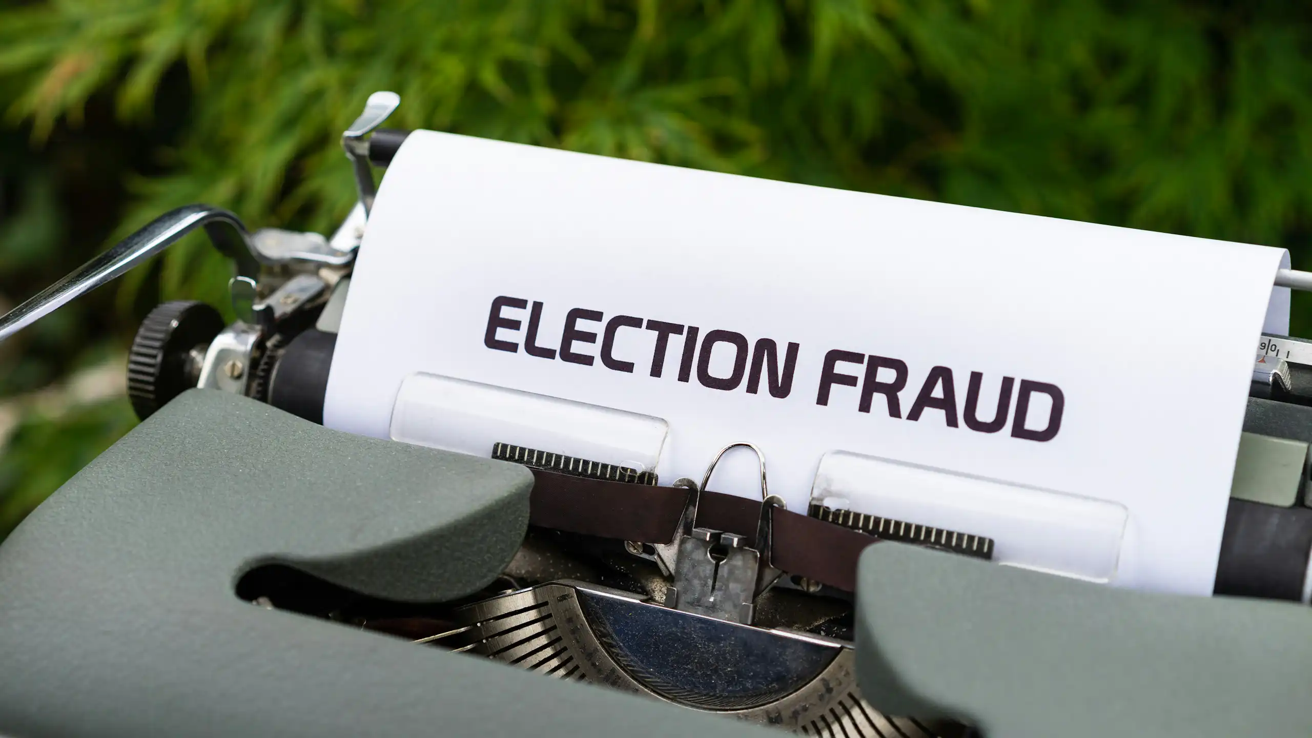 A typewriter with a piece of paper poking out halfway written 'election fraud'