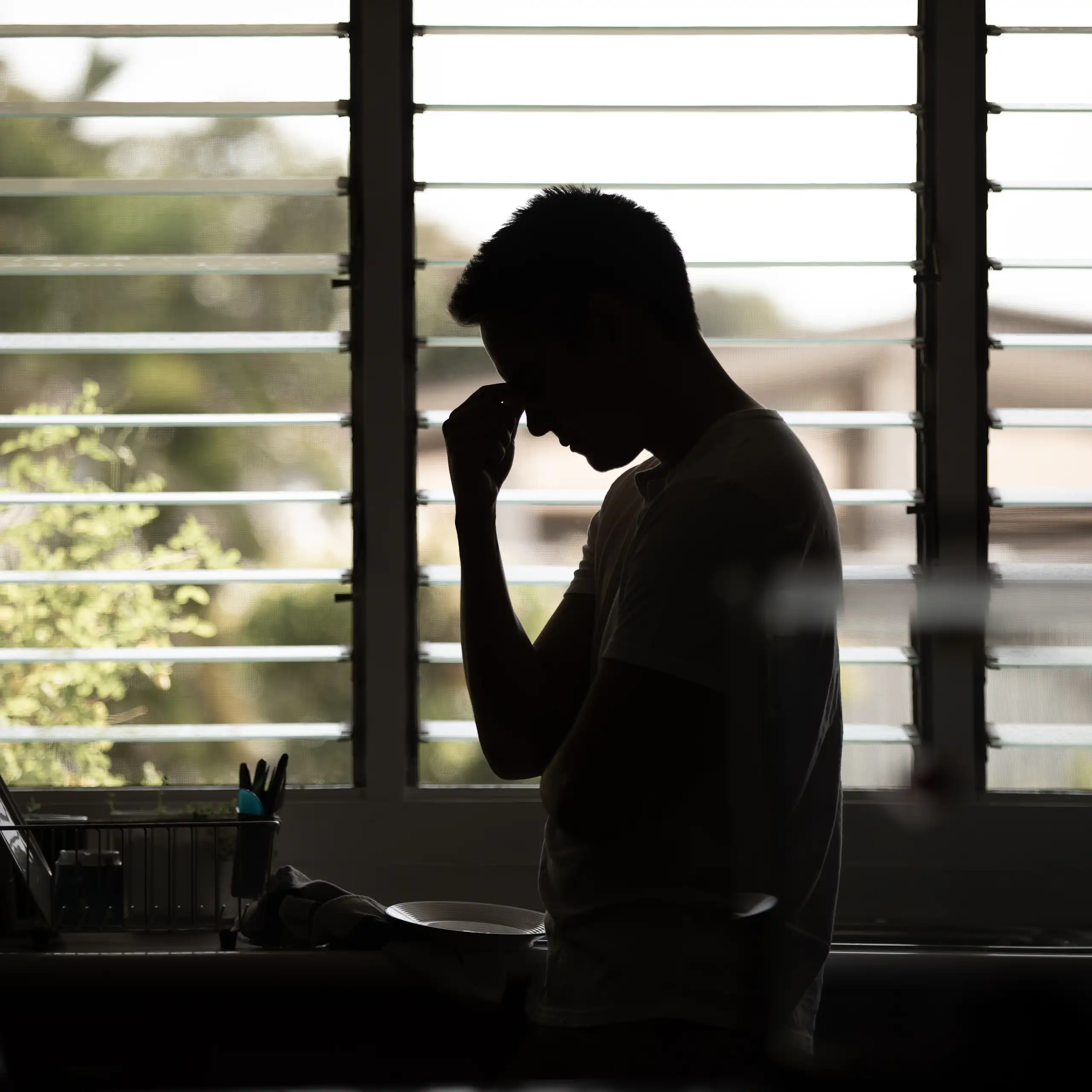 Une silhouette d'homme dans une cuisine.