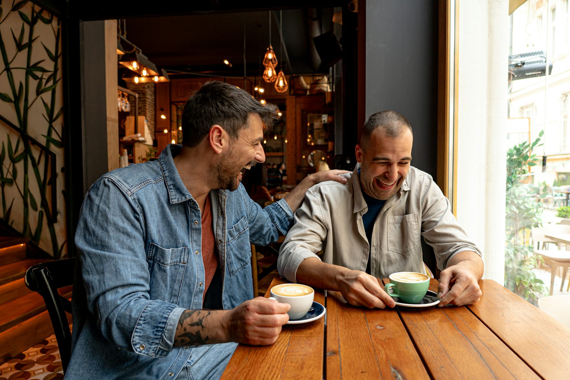 Two men laughing in a coffee shop