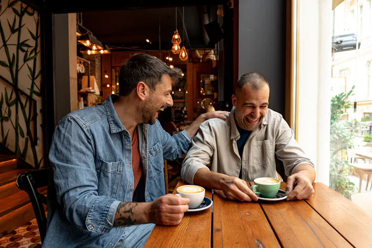 Two men laughing in a coffee shop