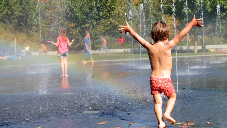Niños jugando entre chorros de agua