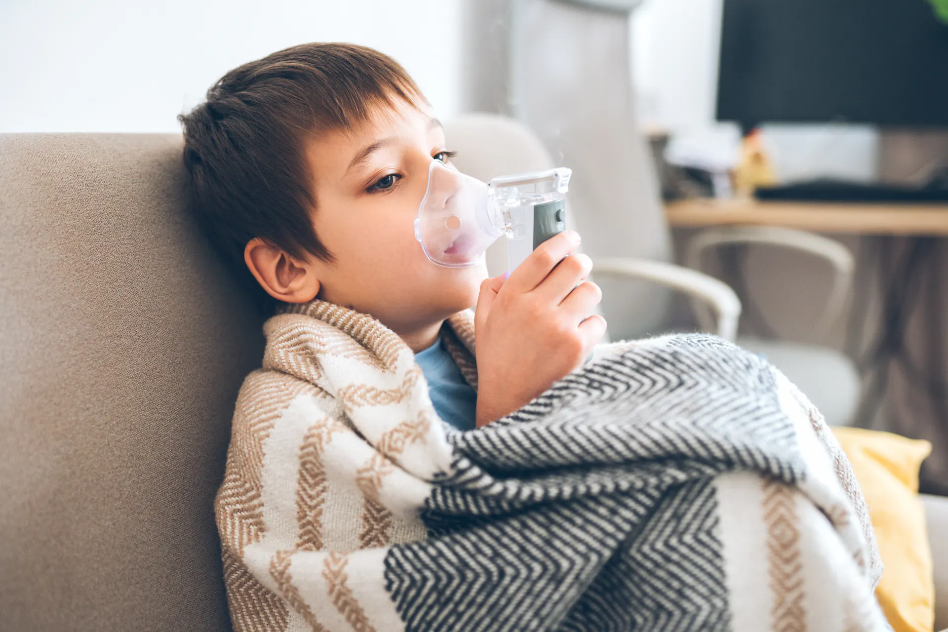 boy in blanket using nebulizer