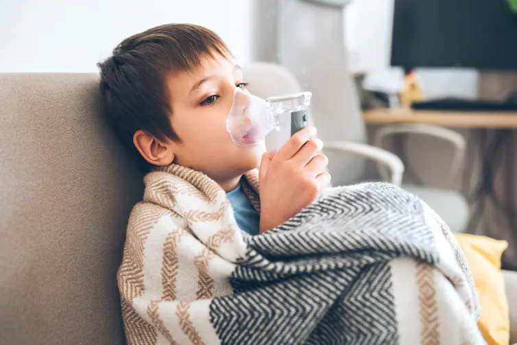 boy in blanket using nebulizer