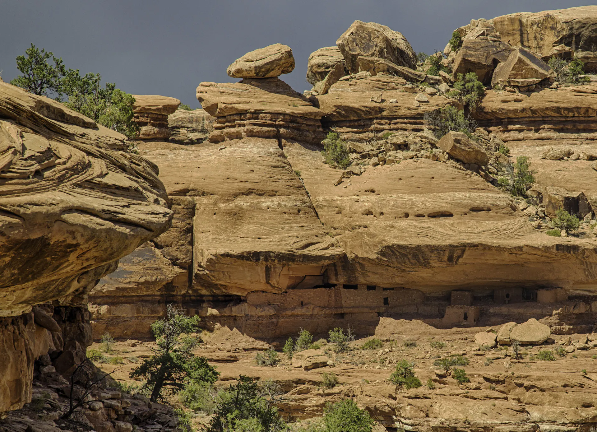 Steep rock formations with a handful of small trees growing on their ledges.