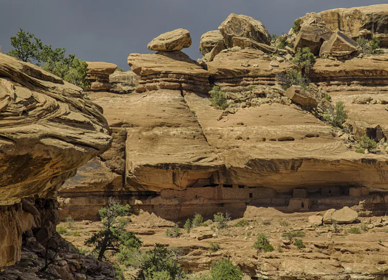 Steep rock formations with a handful of small trees growing on their ledges.