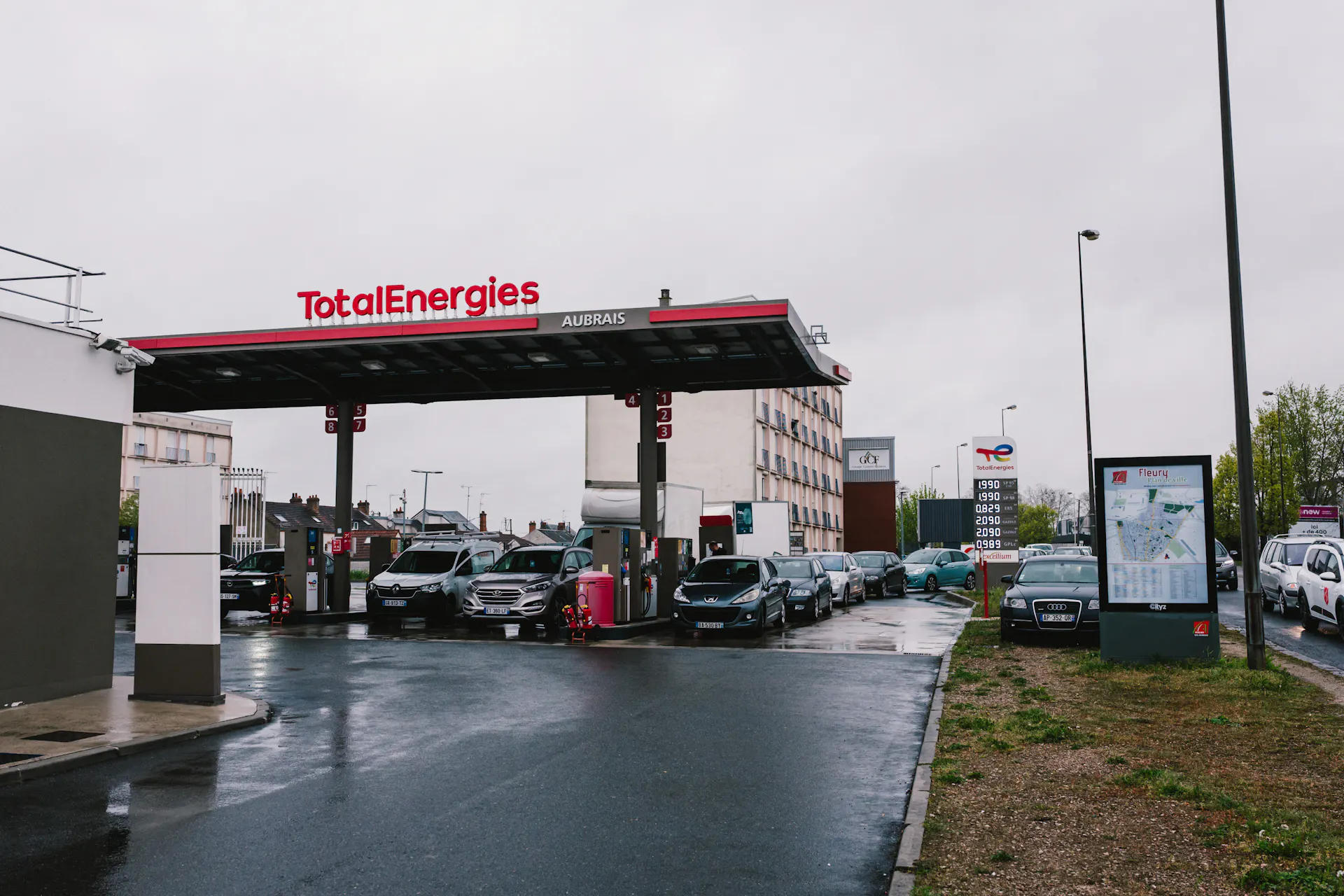 Cars line up at a gas station.