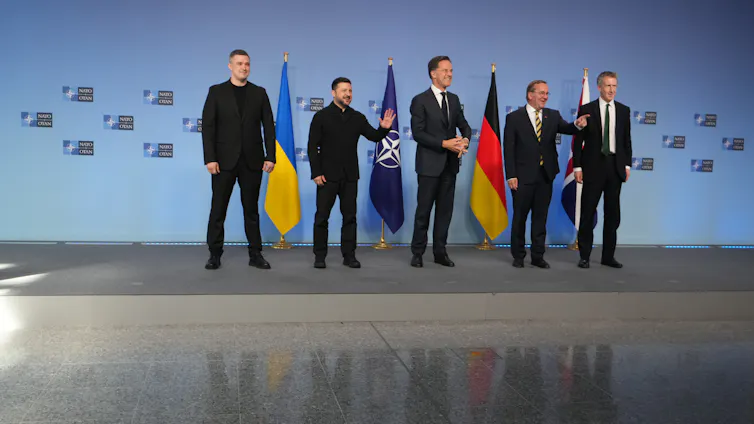 La destitución de dos altos funcionarios de defensa por parte de Vladimir Zelensky pone de relieve el papel de la moralidad en las guerras largas 1 Una fila de hombres está en el escenario.