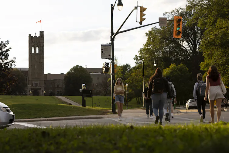 University students cross the street in front of a campus building
