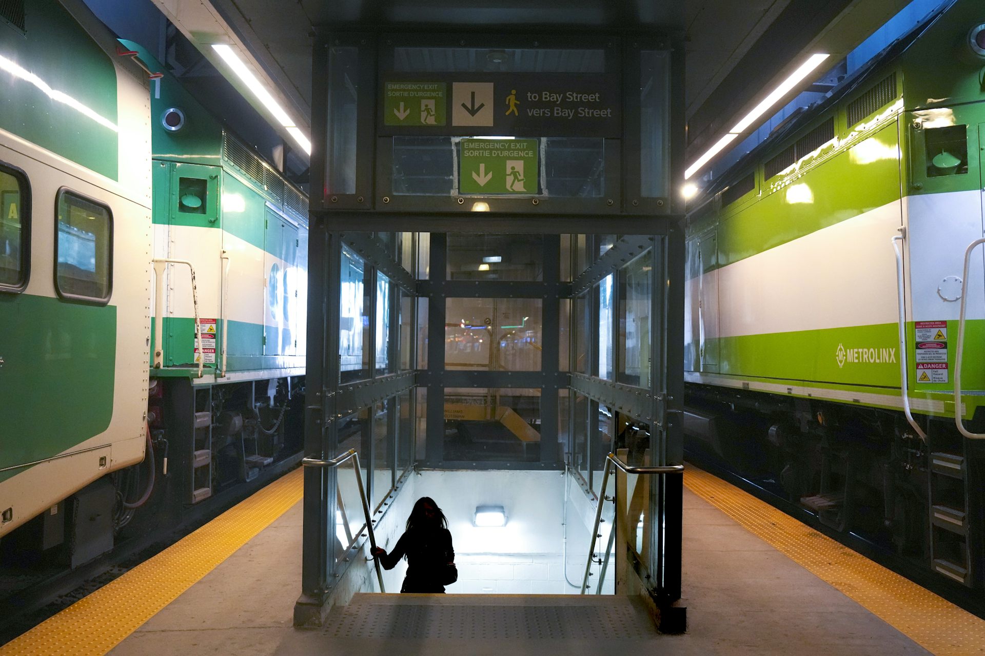 A person walks down the steps from a Go Train platform