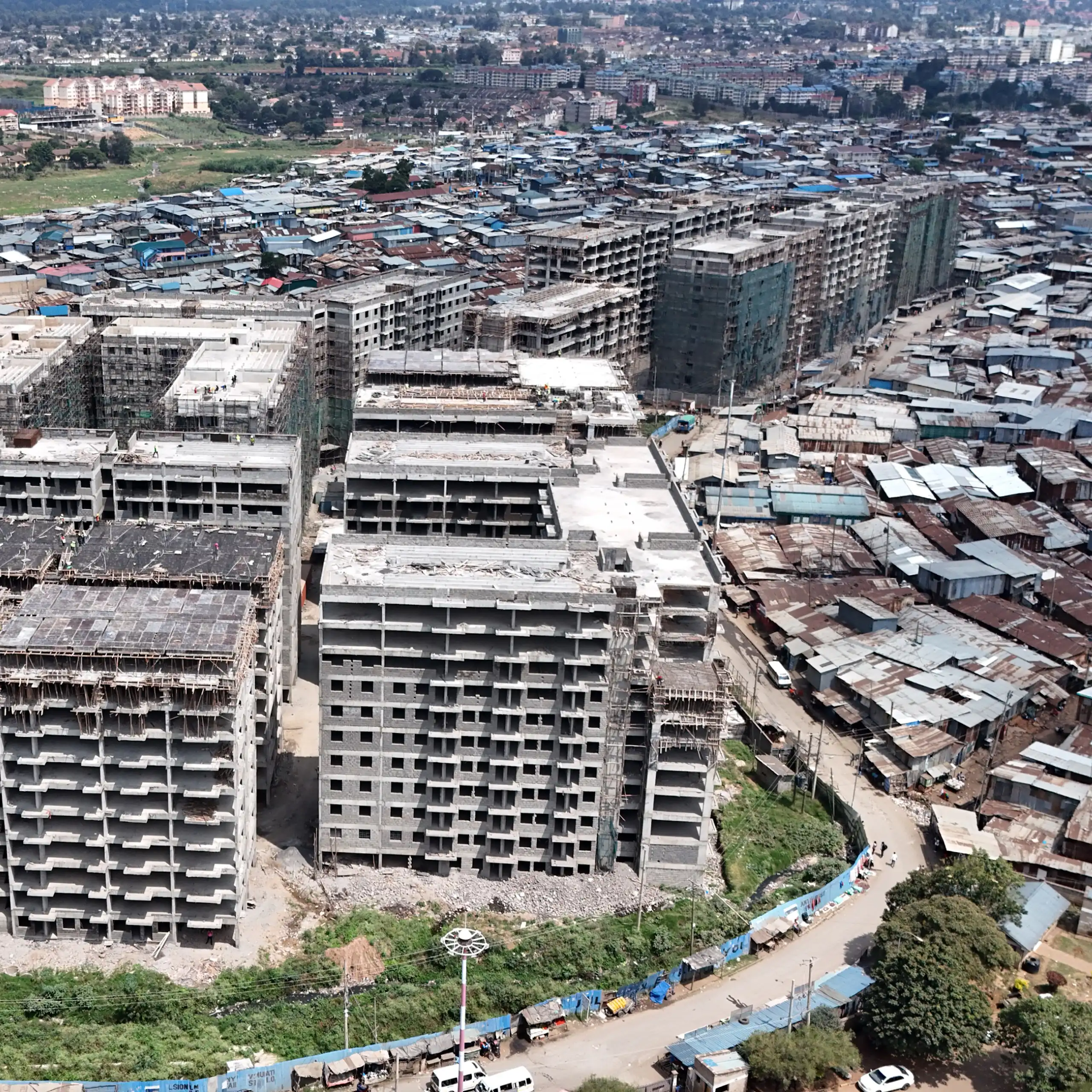 Apartment blocks side by side with low-rise, densely packed corrugated-iron dwellings