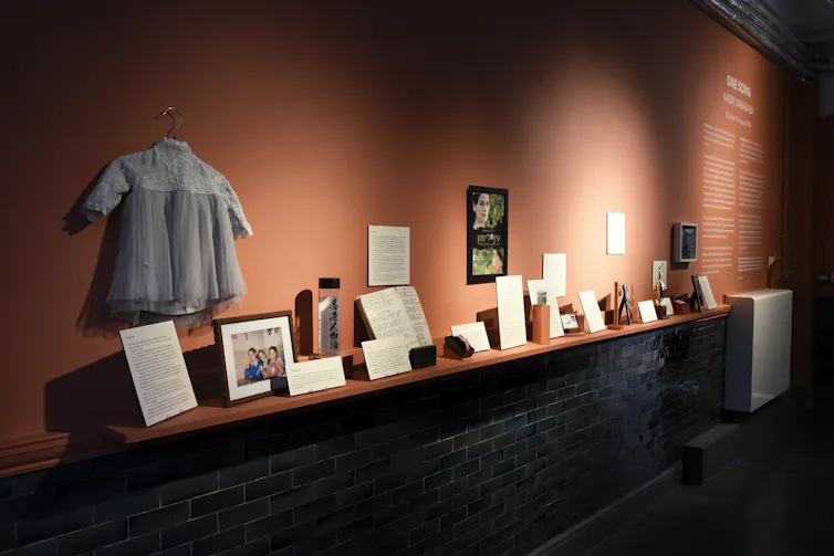 Objects on display in the exhibition including clothing and books.