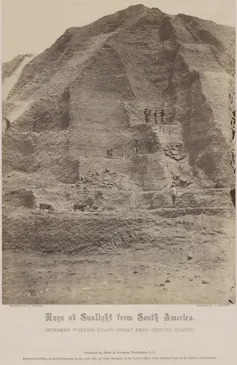 Human figures are visible against a tall mound of material.