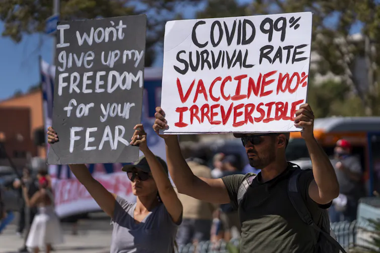 Cómo los escépticos antivacunas utilizan eficazmente la narración para crear mensajes poderosos pero médicamente inexactos 1 Los manifestantes sostienen carteles que dicen