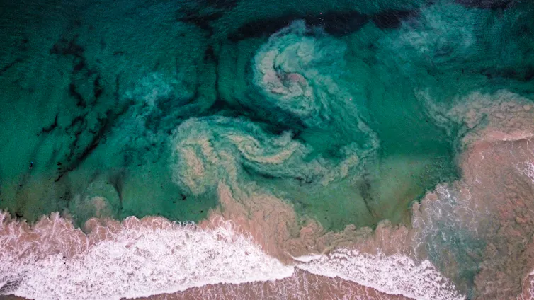 Drone shot of the ocean, with waves appearing to swirl