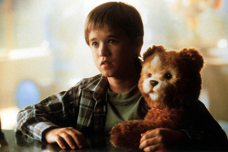Haley Joel Osment holds a teddy bear.
